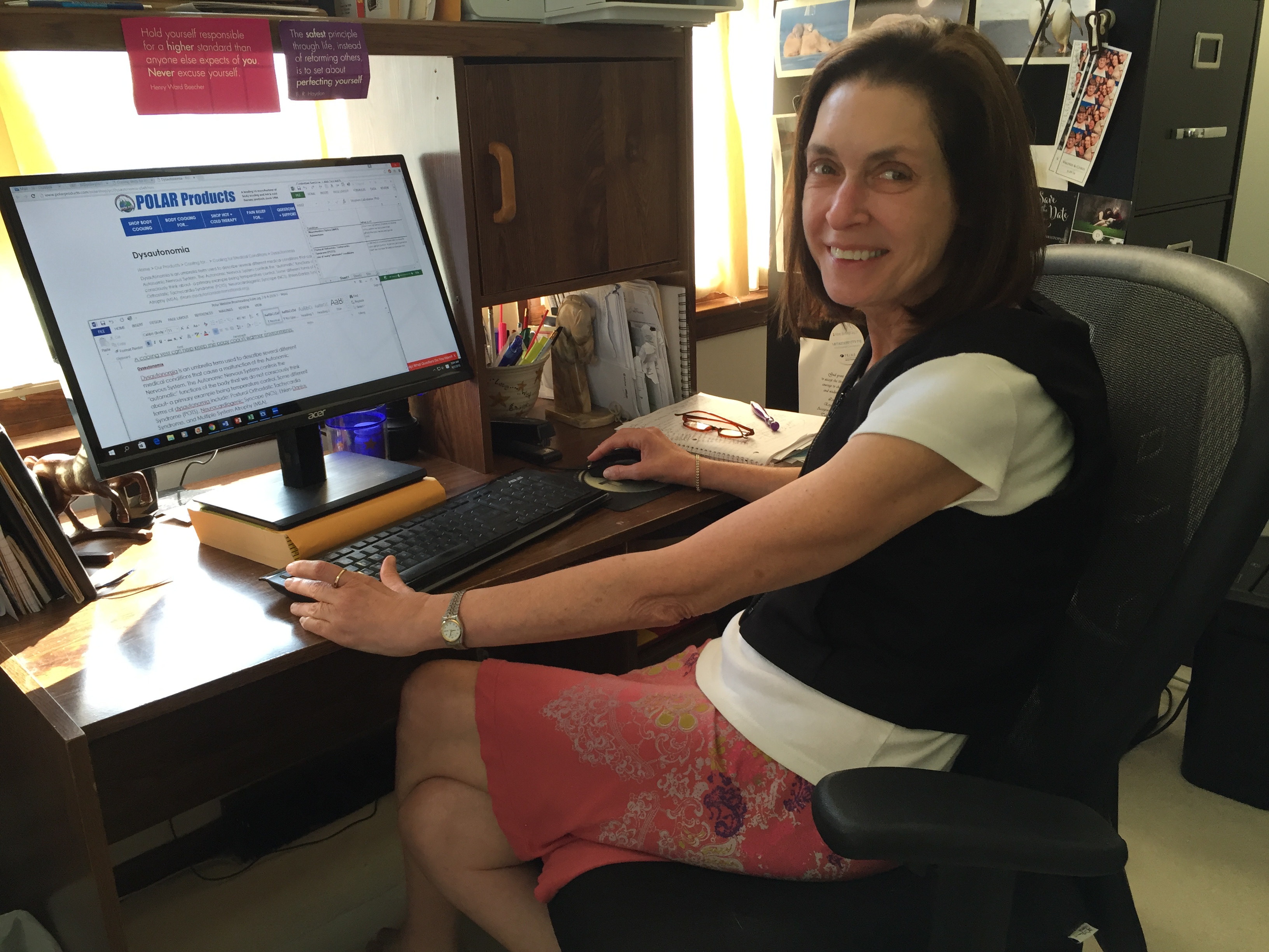 Woman working at a desk wearing a black kool max women's fashion cooling vest